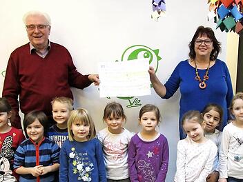 Erich Schie&szlig;er, Vorsitzender des Obst- und Gartenbauvereins, &uuml;bergibt an die Leiterin des Kindergartens, Renate Kr&ouml;ckel, den Scheck. Dar&uuml;ber freut sich auch die "Maxi-Gruppe". Foto: Doris Bauer