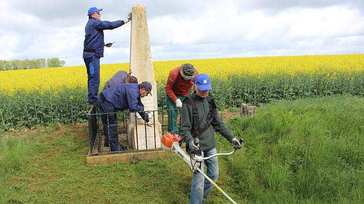 Schneiden, säubern, bürsten: die Großwenkheimer Reservisten - (von links) Herbert Schleier, Tobias Pauli (Bundeswehr), Richard Schleider, Alfred Veeth und Benno Trost - richten ein Denkmal in der Nähe von Metz/Frankreich wieder her. Foto: Paul Ziegler