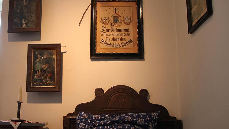 Ein Bild des verstorbenen Sohnes hängt über dem Bett...