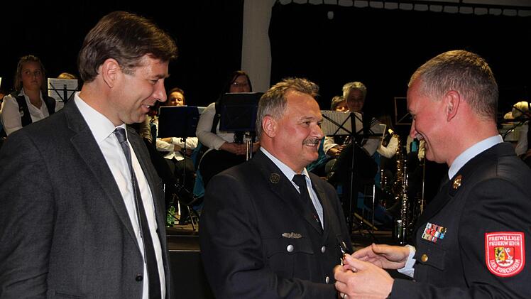 Hans Arneth (mitte) wird von Kreisbrandrat Oliver Flake (rechts) und Landrat Hermann Ulm mit dem Feuerwehrehrenkreuz des Landkreises ausgezeichnet.  Fotos: Mathias Erlwein