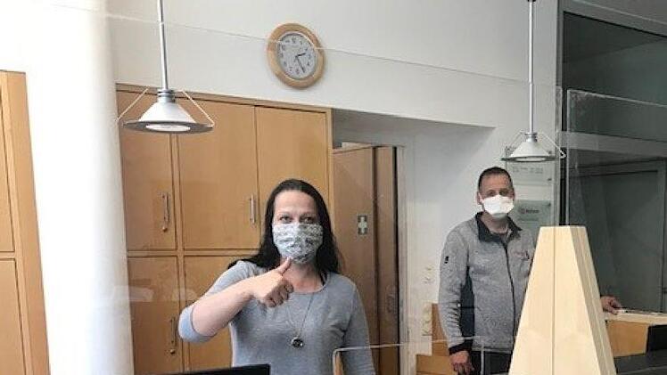Geschützter Empfang: Jacqueline Schenk von der Klinik von Weckbecker und Schreiner Heiko Hergenröder testen die neue Wand aus Plexiglas. Foto: Ellen Morper
