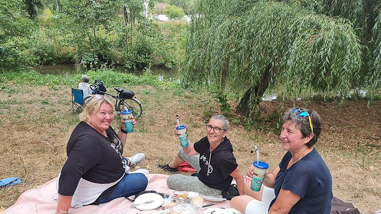"Kulturschnorrer" am Saale-Ufer: Die Freundinnen Micha, Biggi und Gabi (v.l.) haben es sich mit  Getränken und Essen auf der Decke gemütlich gemacht. Foto: Susanne Will