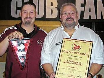 Bernd Hahn (links), Bezirksvorsitzender des Fanverbands, überreicht dem Vorsitzenden Dieter Schönmüller die Ehrenurkunde für den FCN-Fanclub Neubrunn. Foto: privat