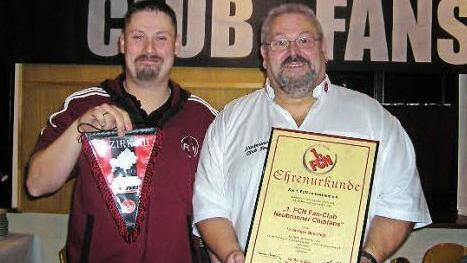 Bernd Hahn (links), Bezirksvorsitzender des Fanverbands, überreicht dem Vorsitzenden Dieter Schönmüller die Ehrenurkunde für den FCN-Fanclub Neubrunn. Foto: privat