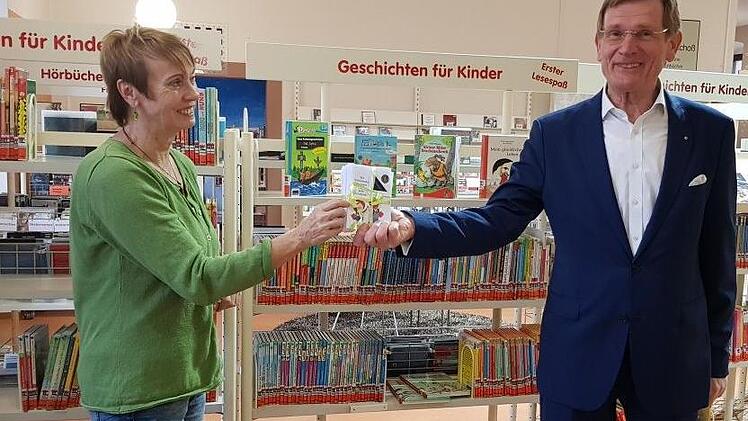 Bibliotheksleiterin Karin Wengerter erhielt von Willy Willeke vom Lions-Club Hammelburg-Bad Brückenau 745 Euro für die Leserausweise, die 159 Erstklässler bekommen.