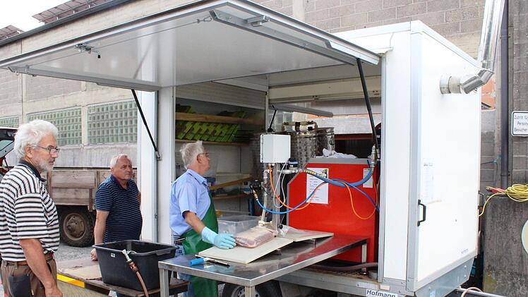 Abfüllen von Saft durch das Saftmobil durch Georg Hofmann (rechts) mit Michael Mager (Mitte) und dem Kunden Bruno Fries