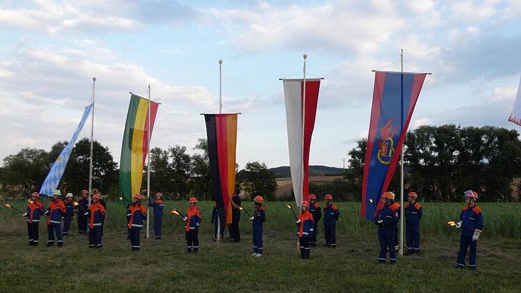 Traditionell werden bei der Er&ouml;ffnung des Zeltlagers die Fahnen gehisst und das Lagerfeuer mit Fackeln entz&uuml;ndet.