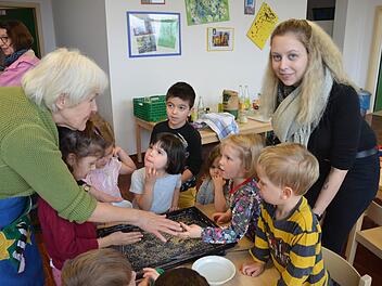 Retta Müller-Schimmel (links) von der Ökofestinitiative und Kinderpflegerin Joenna Hübner bereiten mit den Kindern das Blech fürs Backen der Flädle vor.  Fotos: Bermhard Panzer