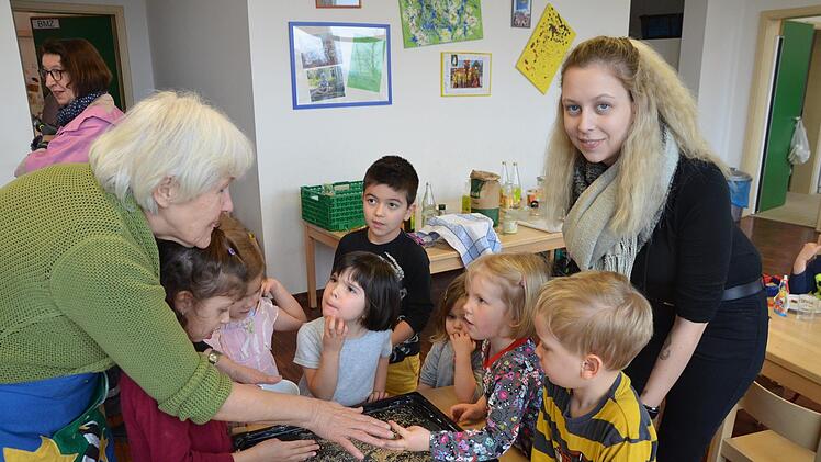 Retta Müller-Schimmel (links) von der Ökofestinitiative und Kinderpflegerin Joenna Hübner bereiten mit den Kindern das Blech fürs Backen der Flädle vor.  Fotos: Bermhard Panzer