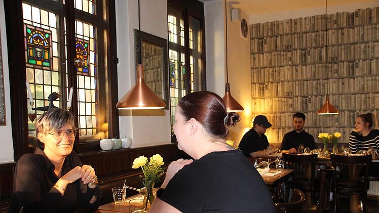 Tina Raab (links) lässt immer einen Tisch als Puffer zwischen den Gästen in der Künstlerklause.  Foto: Sven Dörr