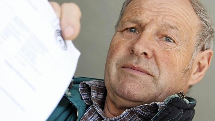 Herbert Graser mit dem Forderungsschreiben der Landwirtschaftlichen Krankenkasse, die rund 2600 Euro Beitragsrückstände von ihm verlangt. Der Kirchaicher zieht dagegen vor Gericht. Er fühlt sich doppelt abkassiert. Foto: Andreas Lösch