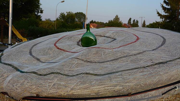 Man braucht nicht viel, um Spaß zu haben: ein Rundballen, einen Bocksbeutel geleert und mit Sand gefüllt sowie aufgezeichnete Ringe  Foto: Assmann