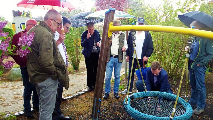 Weiche Platistikteilchen nahmen die Mitglieder des Bad Rodacher Bau- und Umweltausschusses auf dem Haba-Spielplatz in Augenschein. Bürgermeister Tobias Ehrlicher will dieses Material als Schutz auf dem neuen Kinderspielplatz anschaffen. Foto: Volker Gundel
