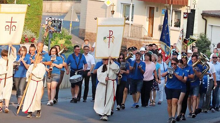 Der Zug der Gläubigen machte sich von der Bushaltestelle auf den Weg zum Pfarrgarten von St. Laurentius. Foto: Johanna Blum