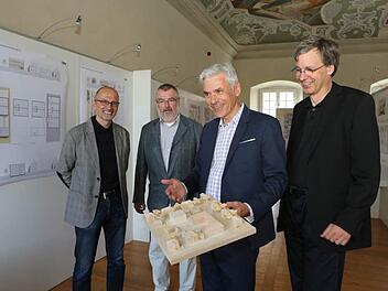 Architekt Peter W. Schmidt erläutert am Modell seinen Entwurf für den neuen Magazinbau. Mit auf dem Bild sind (von links) Hubert Wagner, Stefan Nöth und Thomas Beese. Foto: Barbara Herbst