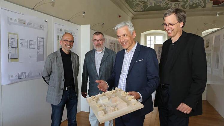 Architekt Peter W. Schmidt erläutert am Modell seinen Entwurf für den neuen Magazinbau. Mit auf dem Bild sind (von links) Hubert Wagner, Stefan Nöth und Thomas Beese. Foto: Barbara Herbst