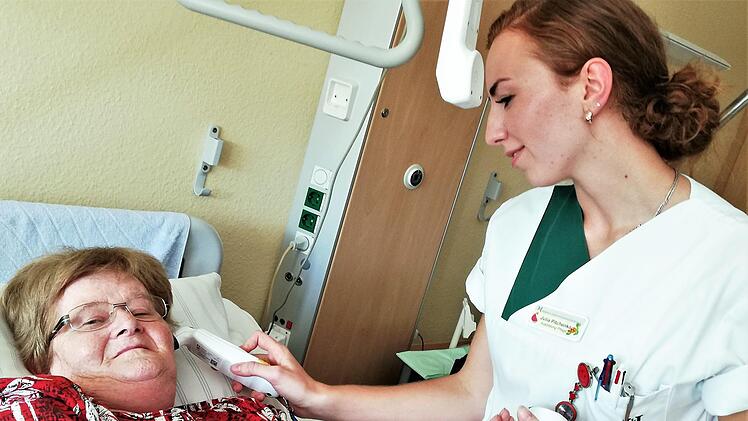 Julia Pitchenko (21) misst bei Patientin Irma Heinicke die Temperatur. Sigismund von Dobschütz