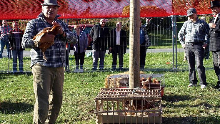 Lächelnd beobachtet Pater Jan (Zweiter von rechts), wie Bürgermeister Peter Hänel endlich das letzte Huhn erwischt, das er ihm großzügig überlassen hat.