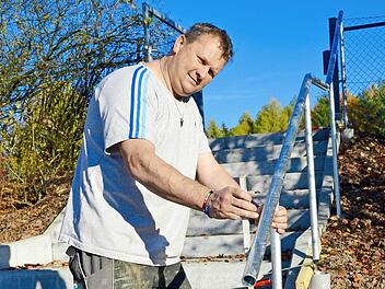 Udo Loiberbecks macht den letzten Check mit dem Zollstock, bevor das neue Geländer einbetoniert wird. Es ist Teil der neuen Treppe, die zum Hartplatz der DJK Premich führt. Dieser kann im Winter jetzt auch von anderen Vereinen angemietet werden. Foto: Kathrin Kupka-Hahn