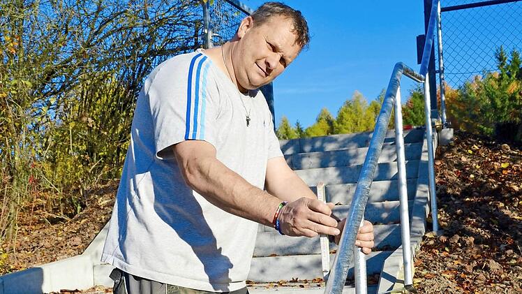 Udo Loiberbecks macht den letzten Check mit dem Zollstock, bevor das neue Geländer einbetoniert wird. Es ist Teil der neuen Treppe, die zum Hartplatz der DJK Premich führt. Dieser kann im Winter jetzt auch von anderen Vereinen angemietet werden. Foto: Kathrin Kupka-Hahn
