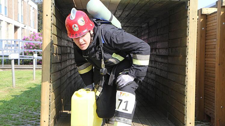 Mit einem Kanister durch einen Tunnel kriechen.