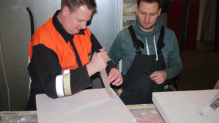 Philipp Ruhhammer und Simon Gerstenkorn diskutieren, wie das Styropor am besten ausgeschnitten wird. Die Stichsäge ist dann das Werkzeug der Wahl.Foto: Katharina Becht
