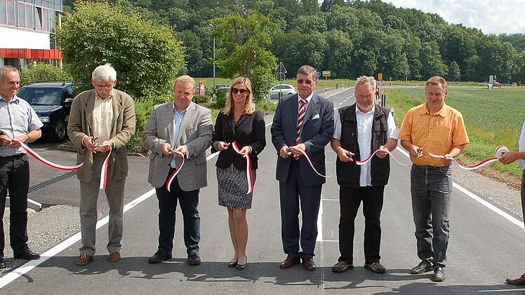 Gaben die Straße mit dem symbolischen Durchschneiden des Absperrbandes frei (von links): Bauhofleiter Herbert Scheler, Werner Wanka, Detlef Bauer, Trixi Preß-Zapf, Gerhard Preß, Ulrich Leicht, Jürgen Faber und Bauamtsleiter Günther Benning.