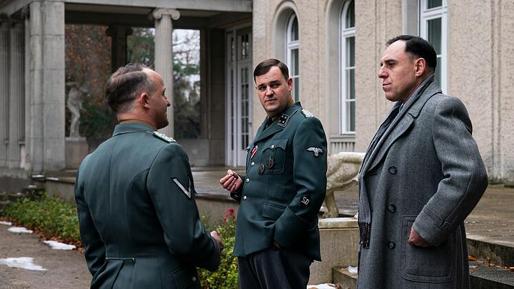 Besprechungspause vor der Villa am Gro&szlig;en Wannsee: Dr. Eberhard Sch&ouml;ngarth (Maximilian Br&uuml;ckner, links), Dr. Rudolf Lange (Frederic Linkemann, Mitte) und Friedrich Wilhelm Kritzinger (Thomas Loibl) besprechen sich.