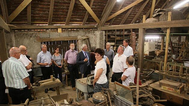 Zwischen landwirtschaftlichem Ger&auml;t aus vielen Jahrzehnten: Die Kreisr&auml;te machten sich in Frensdorf ein Bild vom Depot des Bauernmuseums . Museumsleiterin Birgit Jauernig erkl&auml;rte, wo Probleme liegen. Foto: Schanz