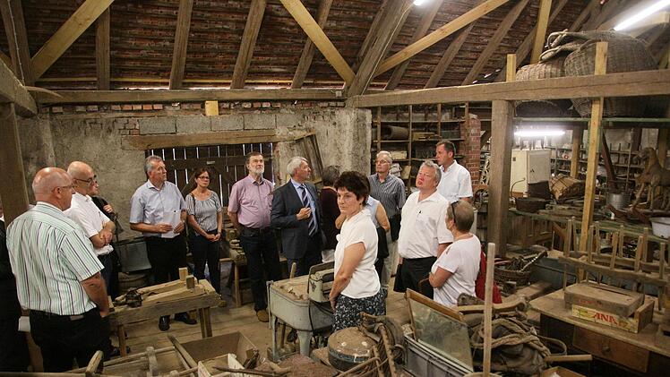 Zwischen landwirtschaftlichem Gerät aus vielen Jahrzehnten: Die Kreisräte machten sich in Frensdorf ein Bild vom Depot des Bauernmuseums . Museumsleiterin Birgit Jauernig erklärte, wo Probleme liegen. Foto: Schanz