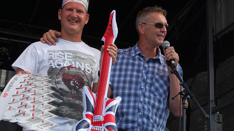 Frank Rubner, der Vorsitzende des Kreisjugendrings, und Veranstalter Stefan Beier Arm in Arm mit einer Luftgitarre. Foto: Thomas Kraus