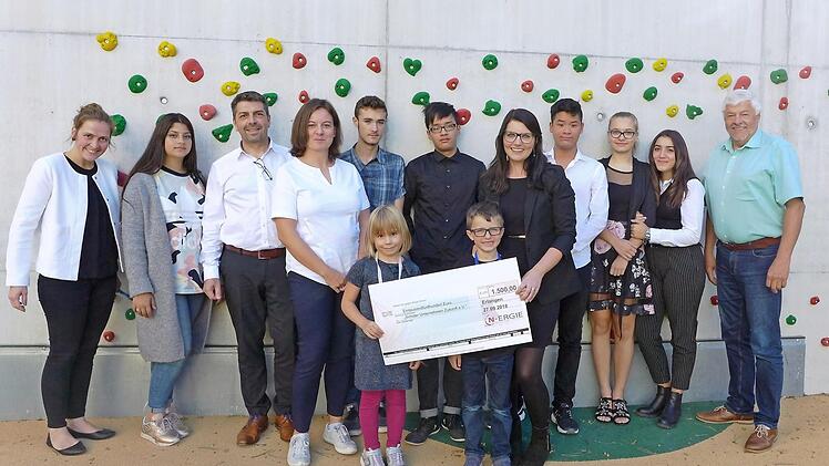 Bei der Spendenübergabe (v. l.): Svenja Dengler (Leitung Jugend-Lernstuben Am Anger 32), Susan, Gerd Heinrich (SUZ), Franziska Heinrich (SUZ), Alessandro, Tien, Stefanie Gandt (SUZ), Kiet, Marcelina, Alfina, Rainer Gründel (Betreuer für kommunale Kunden bei der N-ergie) sowie (vorne) Mathilda und Raphael Foto: PR  