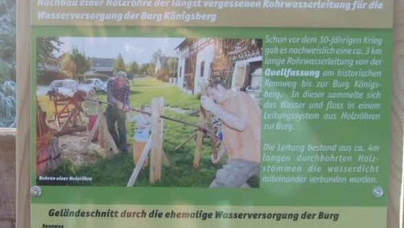Eine Tafel informiert über die historische Wasserleitung, nach deren Vorbild der Stamm durchbohr wurde.