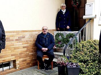 Eine "80", aus frischem Grün gesteckt, dokumentierte den Anlass: Bürgermeister Herwig Neumann (rechts) und Pfarrer Peter Ahrens (links) gratulierten Hellmuth Müller mit gebührendem Abstand zu seinem Geburtstag. Oben auf der Treppe seine Frau Inge.  Foto: Dieter Hübner