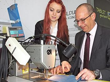 Bei seinem Rundgang durch die Ausbildungsmesse setzte sich der Landrat Christian Meißner am Stand der Polstermöbelfirma Koinor an eine Nähmaschine und fertigte ein Ledermäppchen.