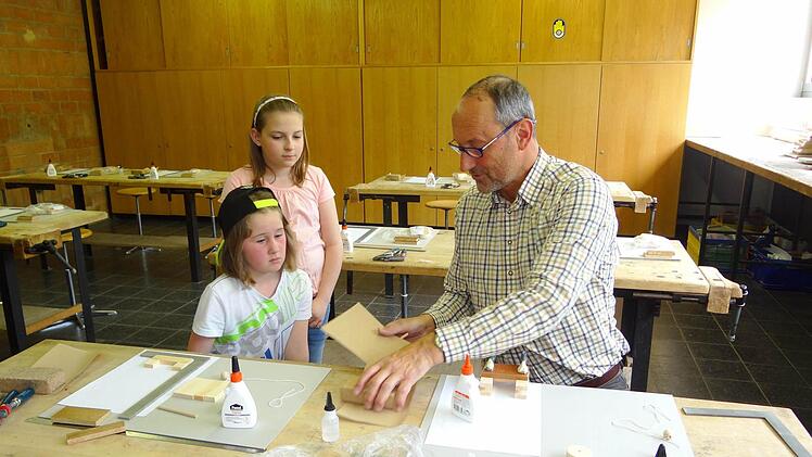 Peter Kreitmeir bastelte mit den Schülerinnen und Schülern einen Zugkreisel in dem Werkraum der Realschule Ebern.