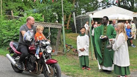 Pfarrer Solomon segnete nach dem Gottesdienst zu Beginn des Kellerfestes des Radfahr- und Motorsportclubs "Viktoria 1912" Dampfach die anwesenden Motorrad- und Fahrradfahrer, darunter Martin Scheppan mit seinem Sohn Levi auf seiner Suzuki .  Foto: Ulrike Langer