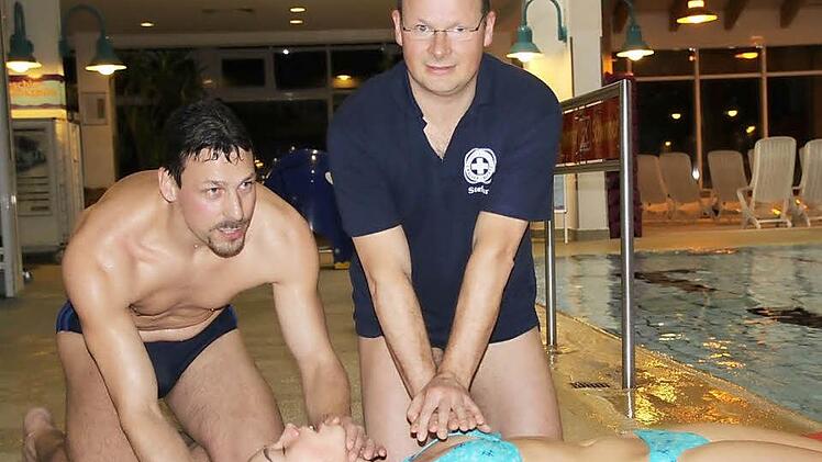 Gewusst wie: Stephan Ritter (von links) und Stefan Scheller demonstrieren die Erste-Hilfe-Leistung nach einem Badeunfall. Fotos: Ulrike Müller