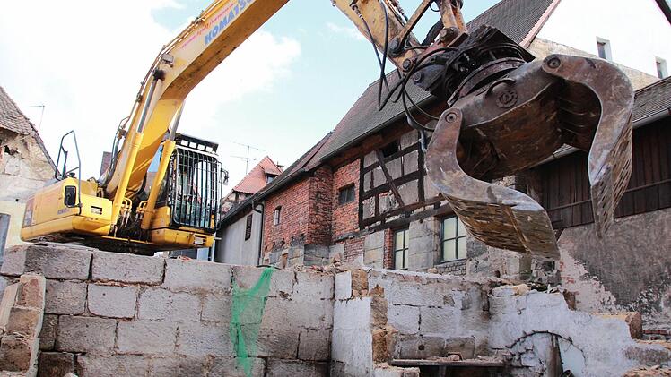 Stück für Stück frisst sich der Bagger durch den morschen Altbau bis nur noch Holz (oben) und Bauschutt übrig bleiben. Fotos: Josef Hofbauer