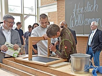 Letzter Feinschliff für die Schiefertafeln: Landrat Michael Busch (links) schaut Martin Wegener und Maximilian Weigand dabei zu.  Fotos: ga