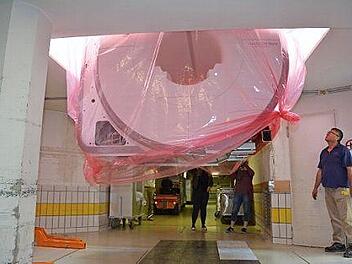 In der Schwebe: Das 1,5 Millionen Euro teure MRT-Ger&auml;t wird durch eine Decken&ouml;ffnung abgelassen. Foto: Frank Schm&auml;lzle