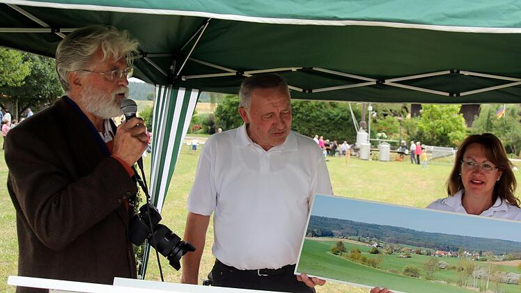 Mit einer neuen Dorfansicht fürs Gemeindehaus überraschte der Heilgersdorfer Wilfried Staub die Organisatoren des Fests, Günther Schramm, Petra Grell und Udo Jahn (von links). Foto: Bettina Knauth