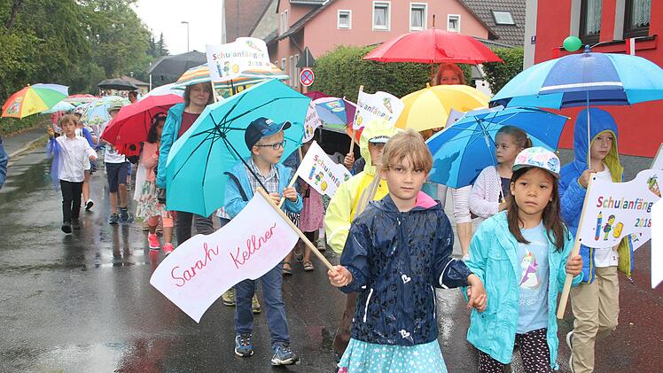 Die Schulanfänger trugen Regenjacken zu den hübschen Blumen-Outfits.