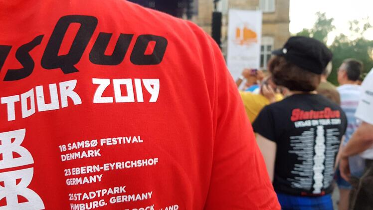 Viele Konzertbesucher hatten bereits lange vor der Jahrtausendwende zu Songs von "Status Quo" getanzt - betagte Fan-Shirts bewiesen es. Am Montag waren die T-Shirts zur "Back"-Tour 2019 der Renner am Merchandising-Stand. Darauf findet sich "Ebern-Eyrichshof Germany" in bester Festival-Location-Gesellschaft.  Foto: Eckehard Kiesewetter