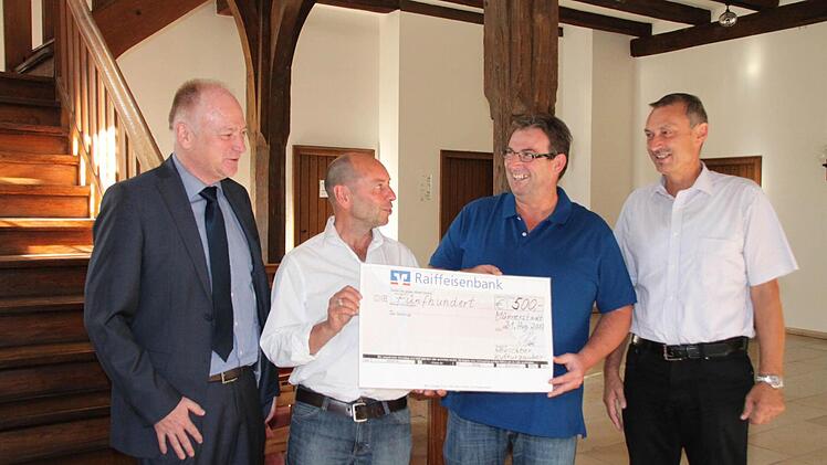 Bernhard Back (rechts) und Thomas Liebst (2. von rechts) überreichen an Charly Friedel einen Spendenscheck, über den sich auch Bürgermeister Helmut Blank freut.  Foto: Heike Beudert