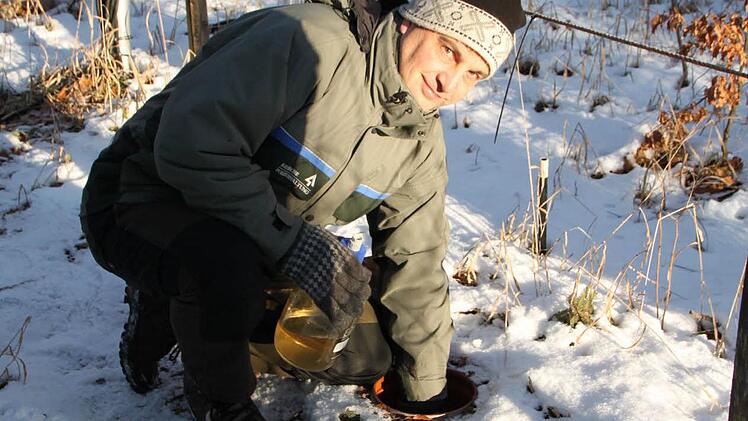 Joachim Dahmer vom Amt für Ernährung, Landwirtschaft und Forsten Bad Neustadt holt eine Flasche mit Sickerwasser aus dem Boden.