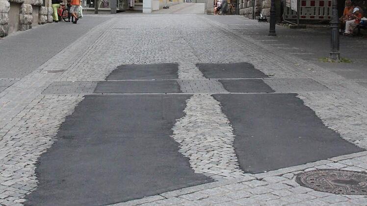 Weil sich im Pflaster Spurrillen bildeten, wurde jetzt mit Asphalt provorisch ausgebessert. Foto: Simone Bastian