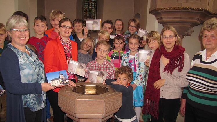 Annerose Kollmann (Kirchenvorstand), Sabrina Göckel (Bürgerstiftung), Tim Weitz, Felix Schult, Christiane Schult und Messnerin Friedegard Herr (vorn, von links) zeigen den Kinderkirchenführer. Fotos: Martin Koch