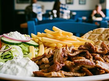 Gyros mit Pommes, Salat und Tsatsiki in einem Restaurant.