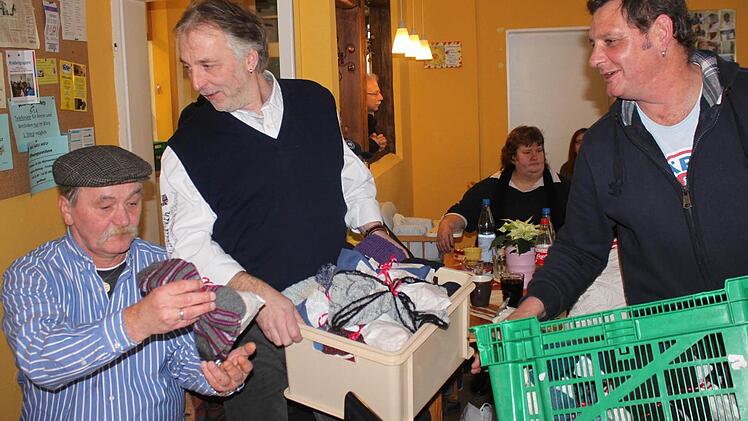 Wärmestubenleiter Claus Poppe (rechts) und Thomas Heinrich, Vorsitzender des Kidro-Vereins, verteilen Geschenke an die Wärmestubengäste.